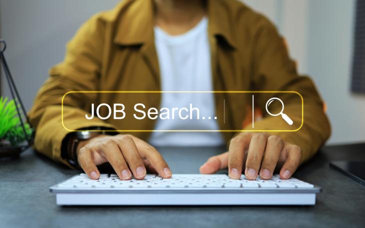 AI Job search man in yellow shirt types into search field 