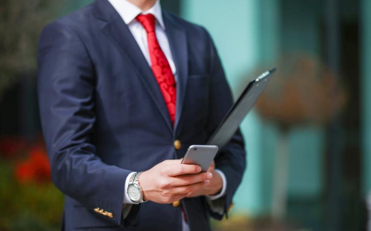 Politician with red tie on phone