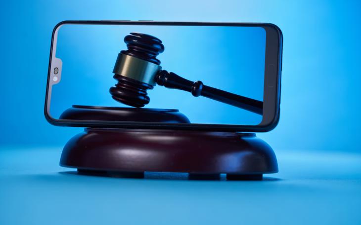 Gavel on a smartphone screen blue back ground