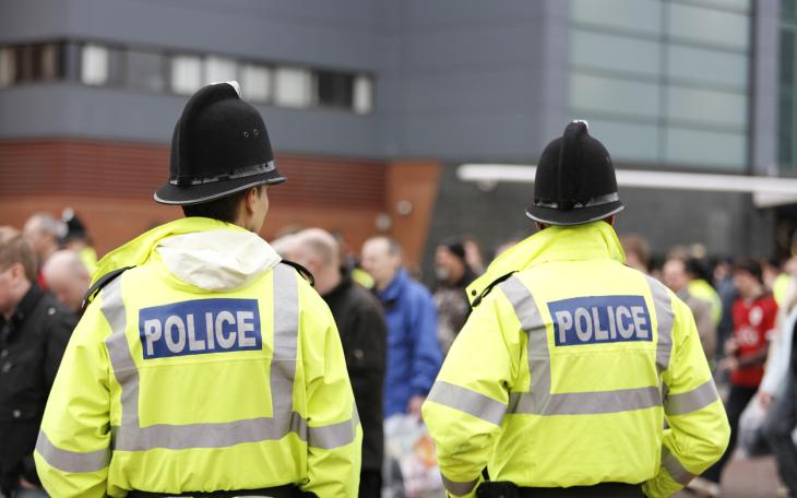 Police men back facing large crowd