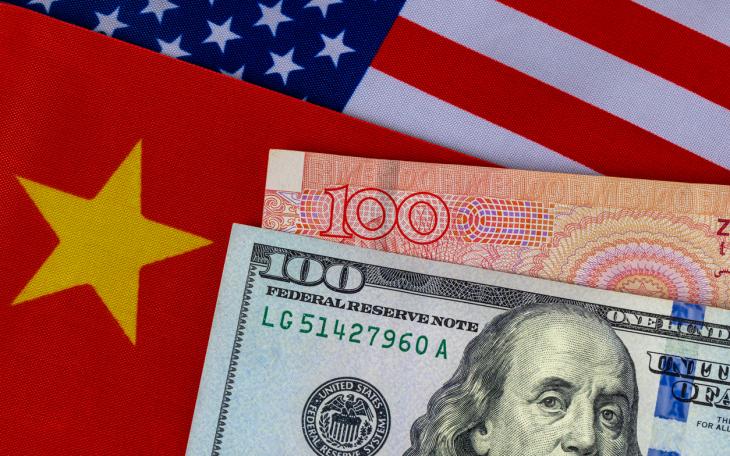 dollar and yuan next to US and Chinese flag