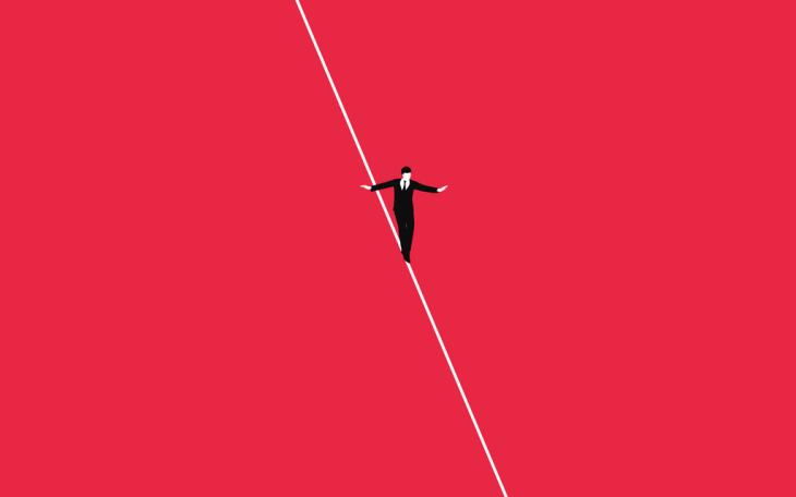 business man in suit walking a tightrope with red background 