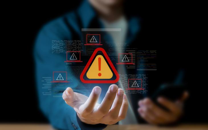 Warning symbol over hand and mobile phone