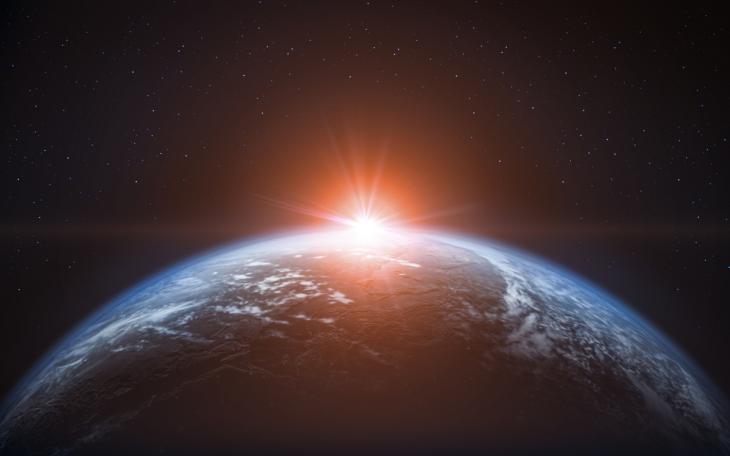 sun rising over the earth from space