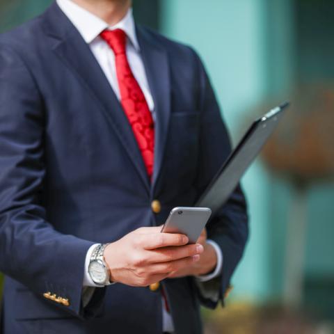 Politician with red tie on phone