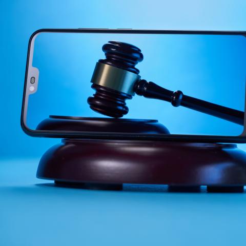 Gavel on a smartphone screen blue back ground