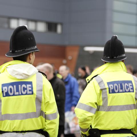 Police men back facing large crowd