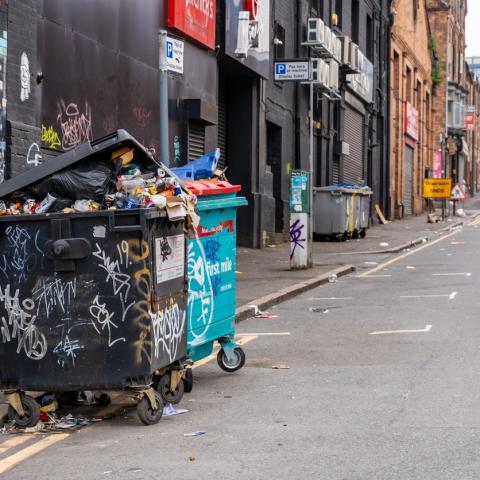 graffiti'd bins overflow on a London road 