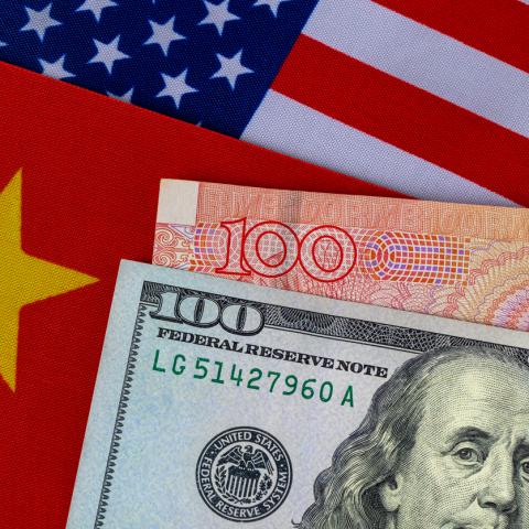 dollar and yuan next to US and Chinese flag