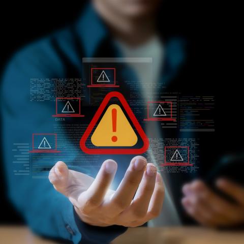 Warning symbol over hand and mobile phone