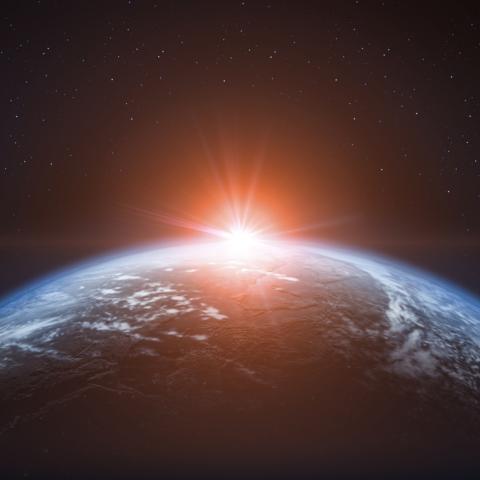 sun rising over the earth from space