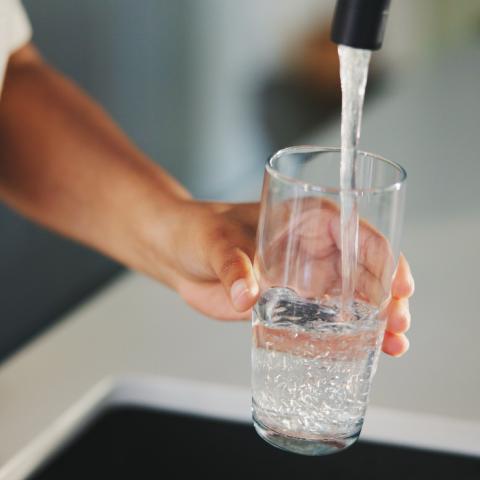 water coming out of tap into glass